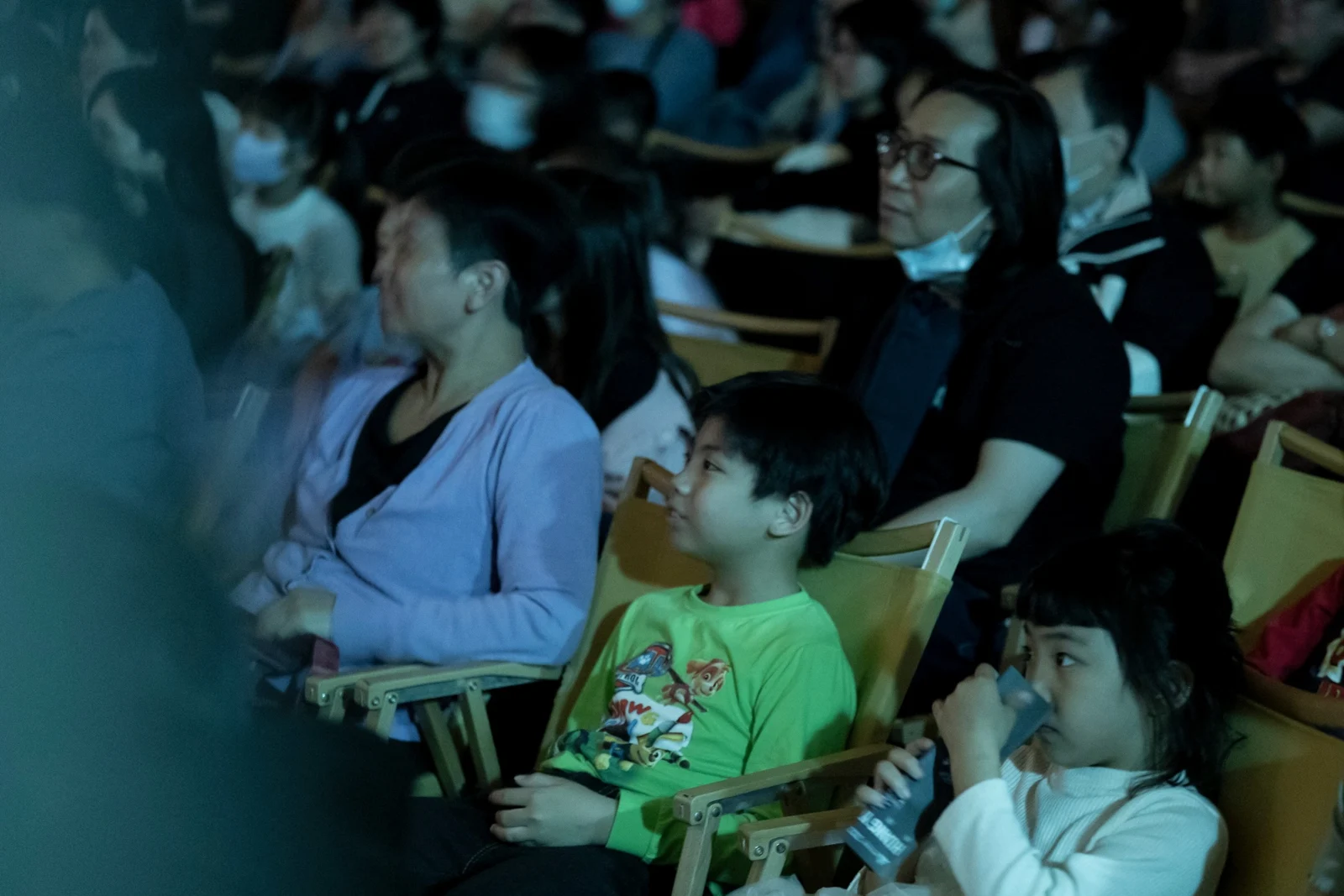 大人與孩子一起，專注欣賞舞台上的演出，自然地露出笑容